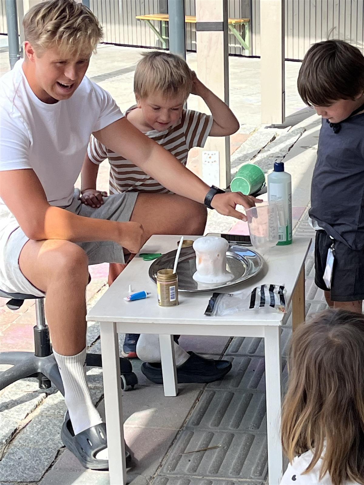 Voksen og 2 barn fryder seg over boblende eksperiment - Klikk for stort bilde